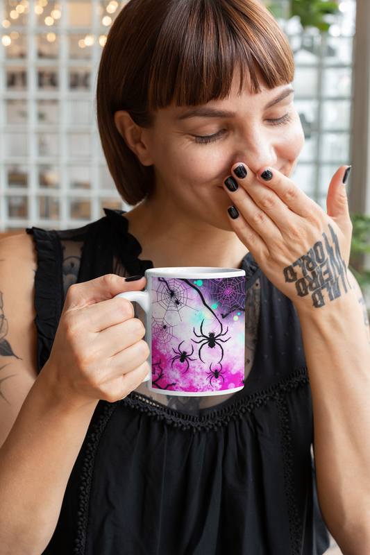 Tattooed woman enjoys her coffee in the Arachnid Web Shadow Ceramic Mug, featuring intricate spider web designs.